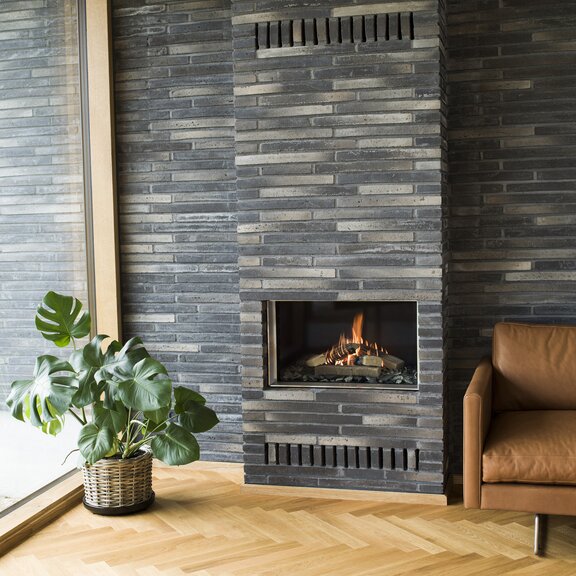 VISIO 70 gas fireplace insert with front glass and modern leather armchair