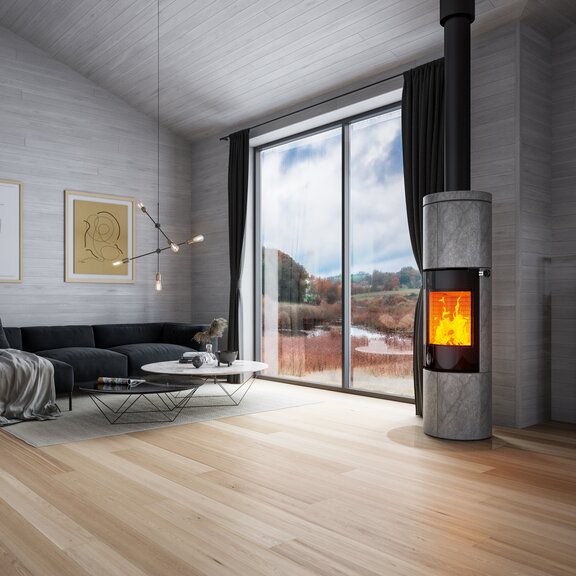 Wood stove JUNO 166 L with soapstone cladding and glass door in a large living room in grey tones