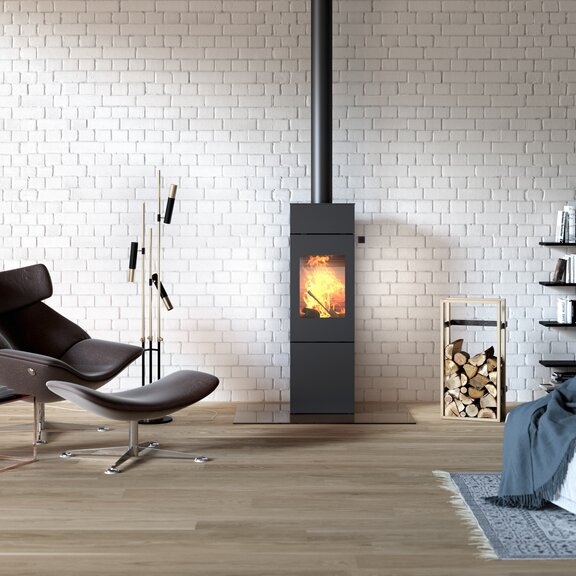 Wood stove NEXO 140 in black with steel door in industrial-style loft with large bookshelf