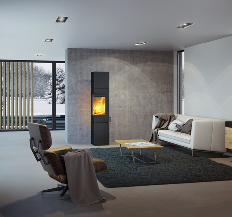 Q-BE XL in black with steel door Wood stove Q-BE XL in black with steel door in a modern living room surrounded by a beautiful snowy landscape