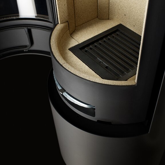 Practical ash grate inside the fire box of VIVA L wood stove in the colour black