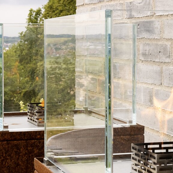 Nice bioethanol fireplaces on rust-coloured steel column on stone wall in the garden